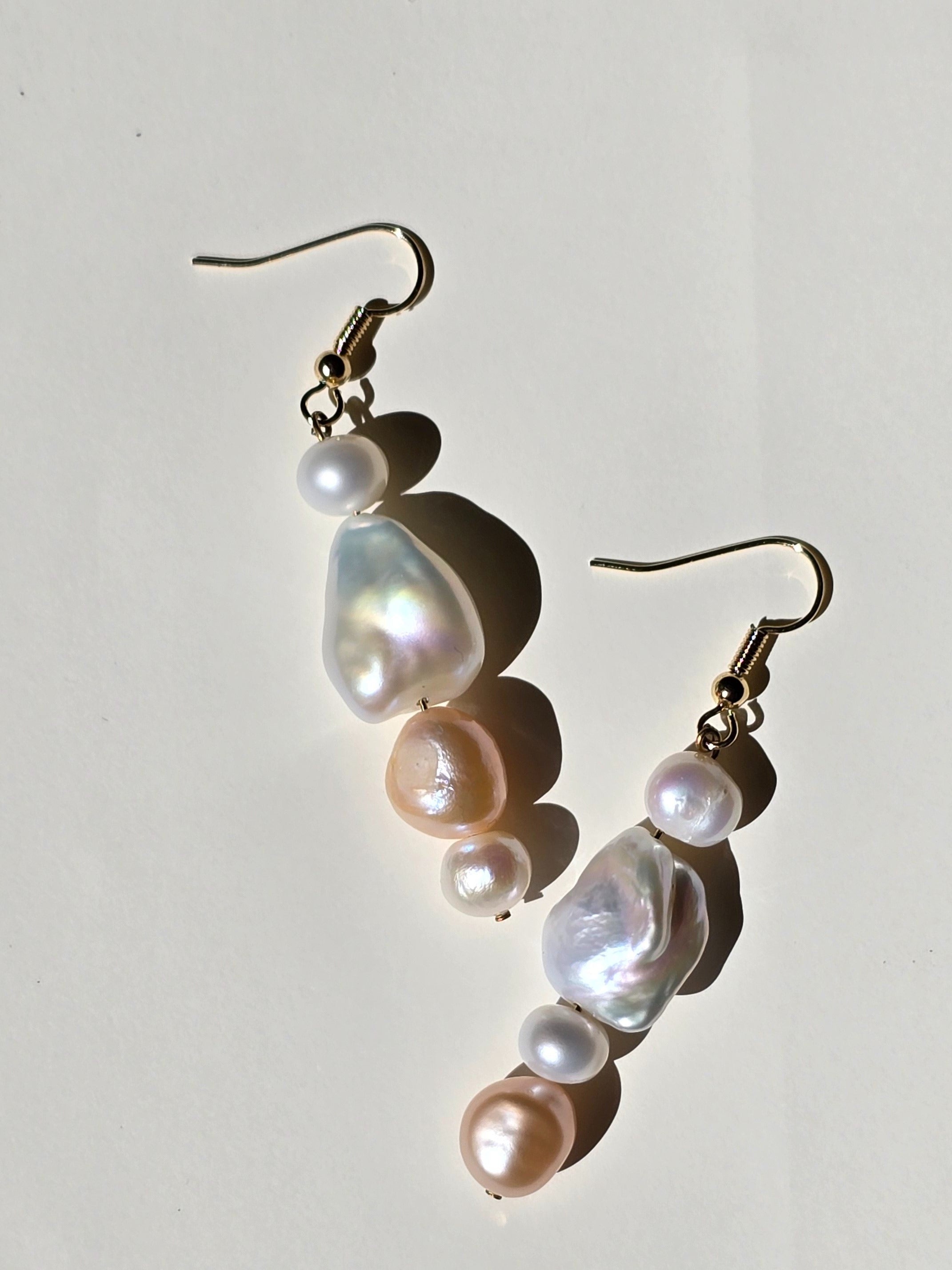 Pair of pearl earrings on a light gray background